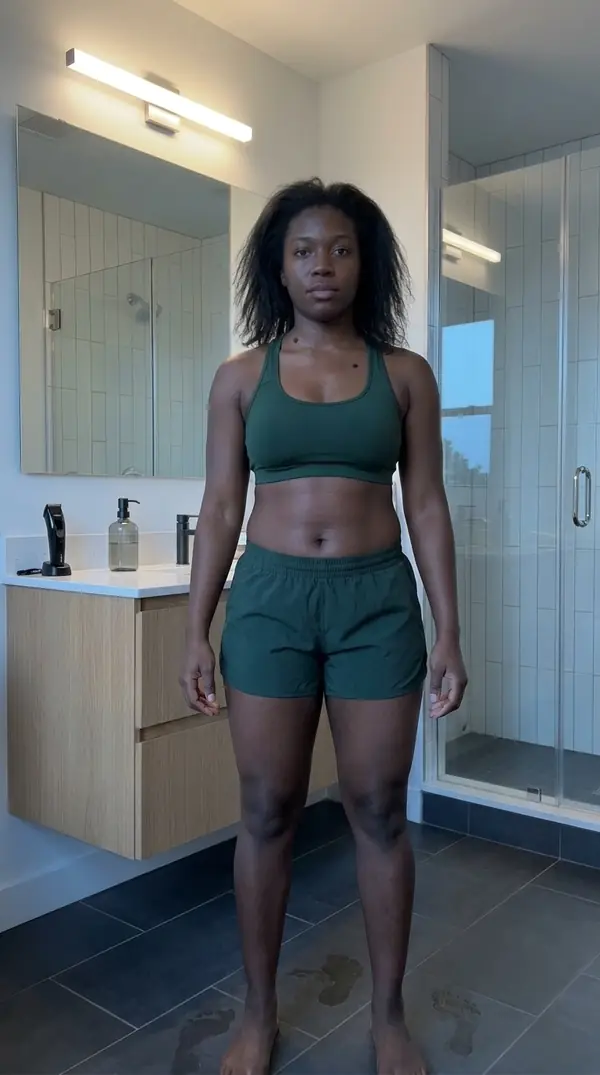 Illustrative sample progress photo of Aisha in a later session, front relaxed pose, with a tighter midsection and more shape in the arms and shoulders